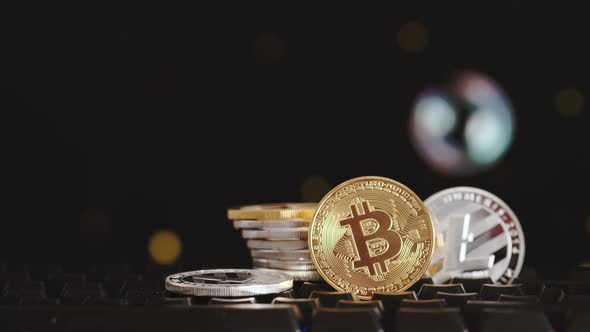 Cryptocurrency Bitcoin and Litecoin on a Black Background with Flying Soap Bubbles alt