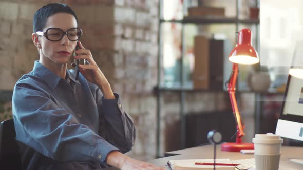 Mid-Aged Businesswoman Having Phone Talk in Office alt