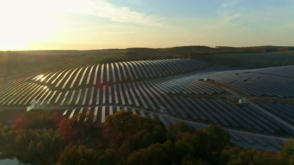 Aerial Drone Footage. Flight Out Above Solar Panel Farm at Sunset Autumn Season