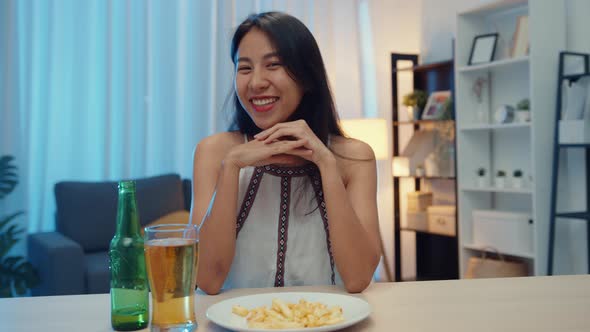 Young Asia lady drinking beer having fun happy night party New Year event online celebration.