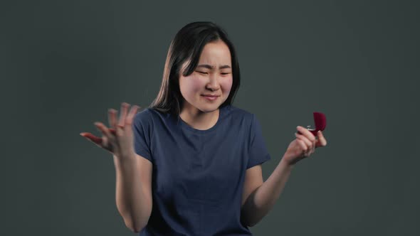 Pretty Asian Young Woman Holding Small Jewelry Box with Marriage Proposal alt