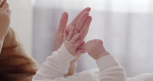 Little Baby Fingers Hold Mom's Hand