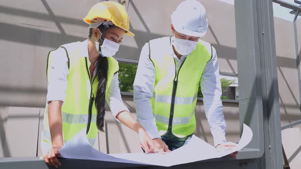 Asian workers people wearing protective face mask onsite of architecture due to covid 19 pandemic alt