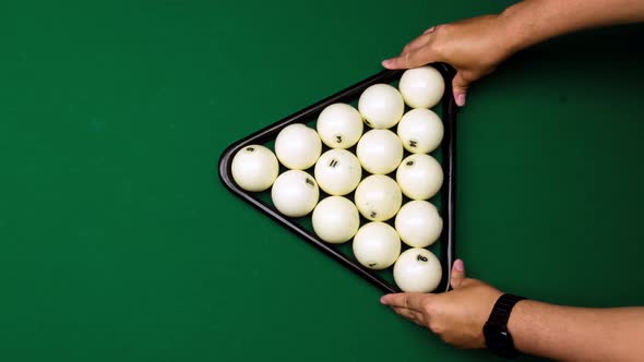 Men Hands Place Pyramid of White Balls with Help of Triangle on Billiard Table and They are Beaten alt