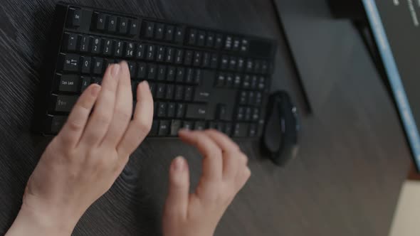 Vertical Video Closeup of Caucasian Programer Hands Typing Code on Keyboard in Front of Computer alt