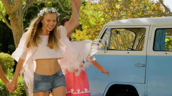 A group of friends smiling and dancing together alt