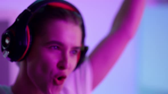 Happy Woman Celebrating Victory in Neon Room Closeup alt