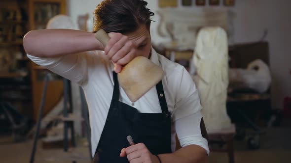Young Stonemason Working in His Worksop with Hammer, Chisel alt