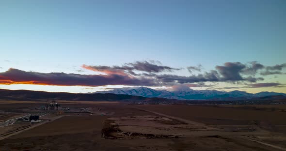 Colorful cloudscape over the distant snowy mountains - aerial hyper lapse alt