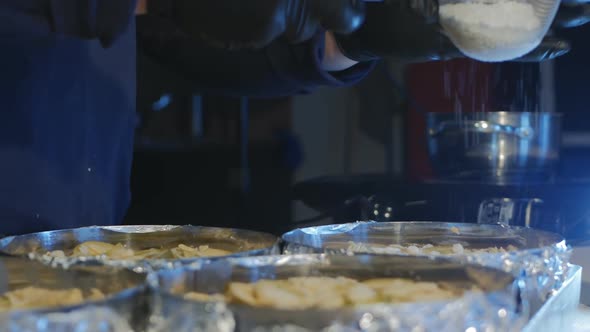a Pastry Chef Sifts Powdered Sugar Onto Many Round Shaped Pies Before Baking at a High Temperature