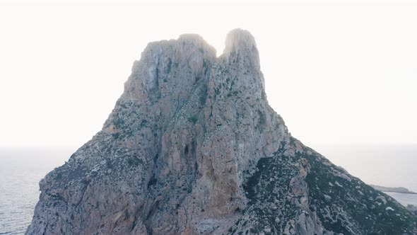 Dark Blue Ocean Waters in Daylight with a Tall Cliff in the Middle alt