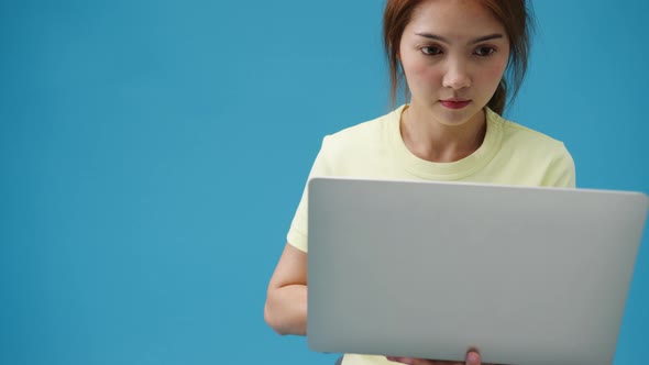 Young girl shopping online with laptop and payment order online isolated over blue background.