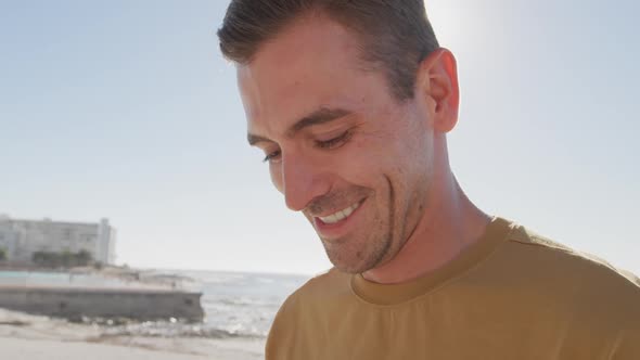 Young man on a beach smiling alt