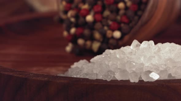 Colorful Pepper Falling on a Wooden Table with Salt alt