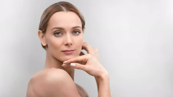 Seductive Naked Beautiful Female Touching Face Neck Shoulder Smooth Skin Posing Looking at Camera alt