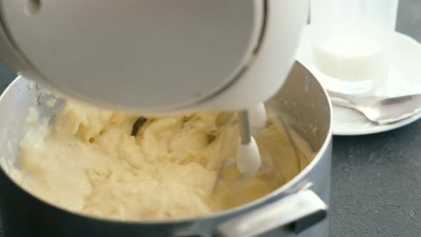  Woman's Hand Making Mashed Potato with Mixer in Saucepan. Cooking Mashed Potatoes.