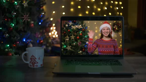 Smiling Woman with Santa Hat Wishing a Merry Christmas Online