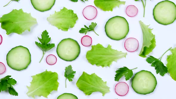 Rotating Vegetable Background of Lettuce Leaves Cucumber Slices Radishes and Parsley Leaves on a