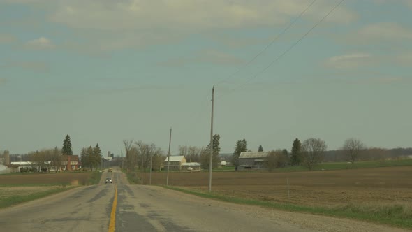 Panoramic view of a road, fields and trees