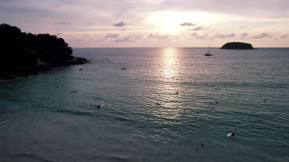 Surfers Catch Waves at Sunset alt