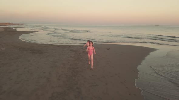 Young Sister and Brother Who Are Playing in the Sea