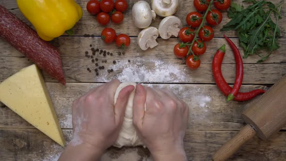 on a Wooden Table Pizza Ingredients and Women Hands are Kneading the Dough