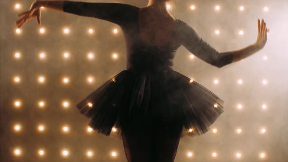 Silhouette of Ballerina in Black Tutu Is Dancing Ballet in the Dark Studio