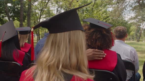 Diverse Proud Parents Embracing Multiracial Graduates at Graduation Ceremony alt