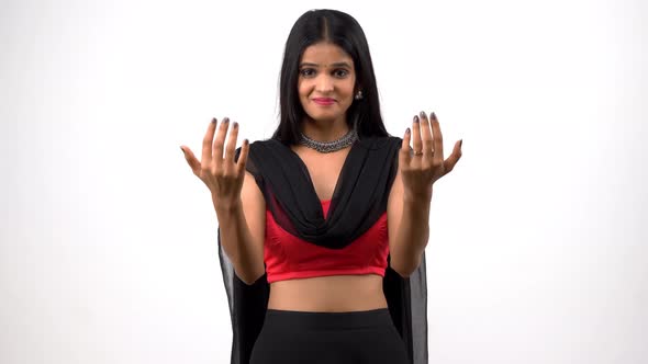 A happy and cheerful Indian girl in ethnic wear calling someone towards her alt