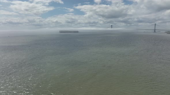 An aerial view of Gravesend Bay in Brooklyn, NY on a sunny day with blue skies and clouds. A dense f alt