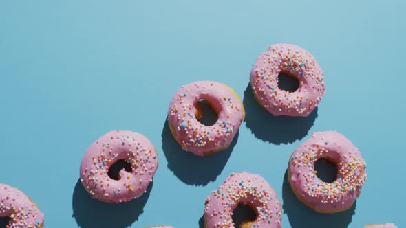 Video of donuts with icing on blue background alt