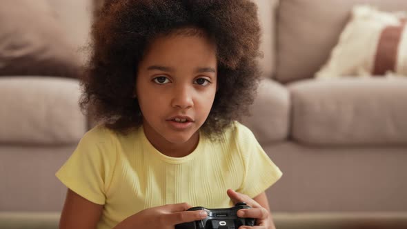Portrait Little African American Girl Playing Video Game Using Wireless Controller alt
