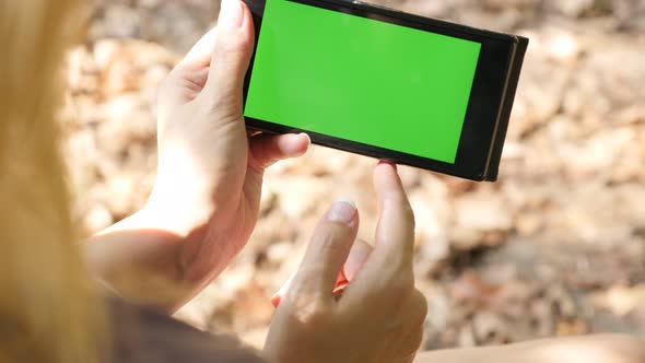 Smart phone with green screen display  in nature close-up 4K 2160p UltraHD footage - Woman holding i alt