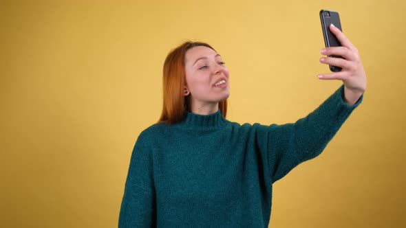 Amazing Cheerful Young Woman in Green Sweaters Taking Selfie