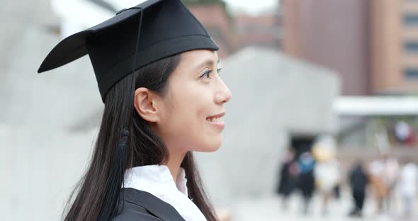 Cheerful woman with graduation gown alt