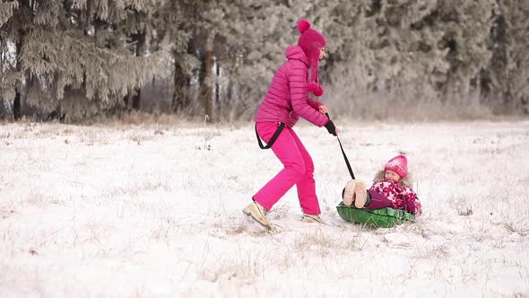 Young Mother and Little Daughter on the Snow