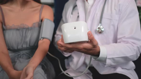Close up doctor explain blood pressure result to patient in reception area of beauty clinic alt
