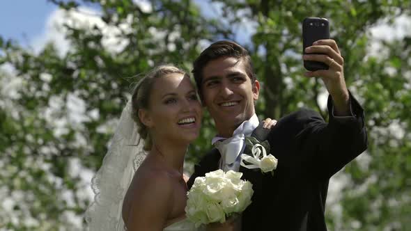 Bride and Groom Taking a Selfie Outside alt