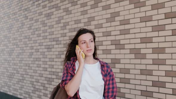 Girl Student Talking To a Friend on an Open Smartphone alt