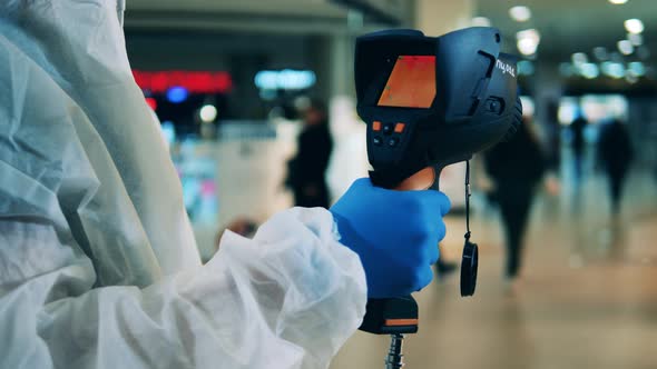 Medical Worker Is Using a Thermovision Device To Scan People alt