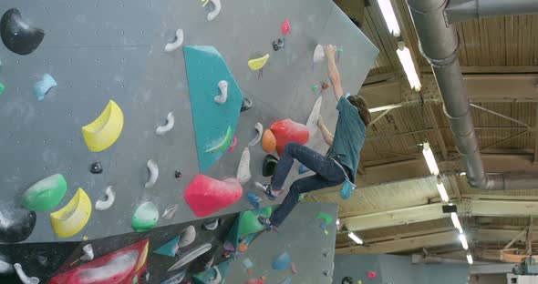 Man Climbs the Wall Climber Training on a Climbing Wall Practicing Rockclimbing Mountaineer Training alt