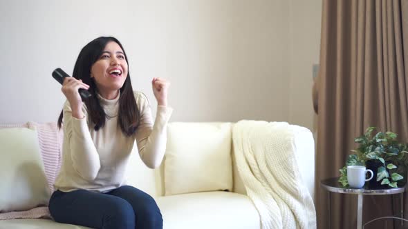 Woman watching TV at home with happy emotion