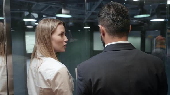 Business partners discussing time-schedule in lift