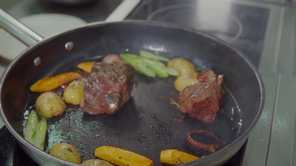 Cook Is Frying Meat and Vegetable Ragout in Pan with Oil alt