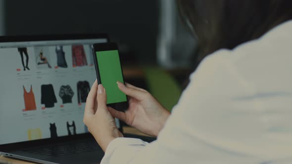 Woman with Open Shopping Website on Laptop and Green Screen of Telephone alt