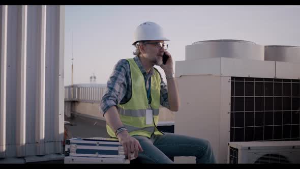 Engineer Having Phone Call on a Cell Tower alt