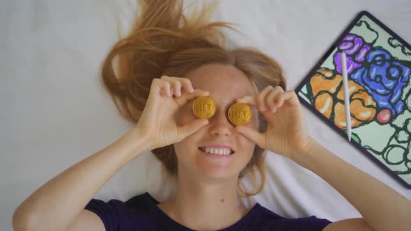 Woman Digital Artist Contemporary Painter Holds Two NFT Coins in Her Hands alt