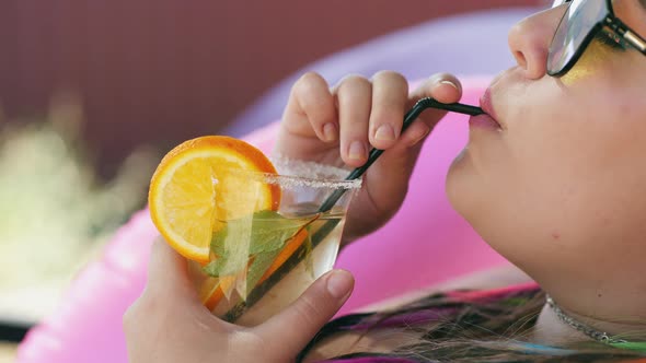 Overweight Girl Drinks an Alcoholic Drink From a Straw alt