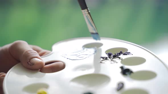 Palette and brush close-up in nature. alt