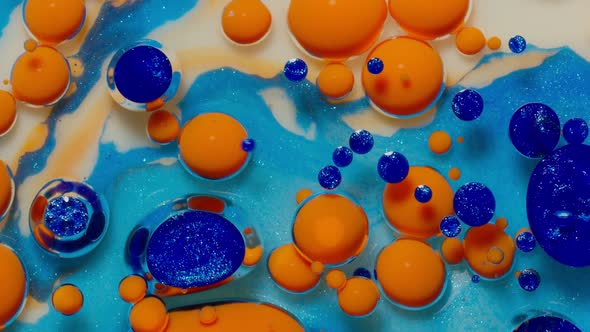 Top View Movement of Orange Oil Ink Drops Bubbles Multicolored Artistic Paint Surface Background alt